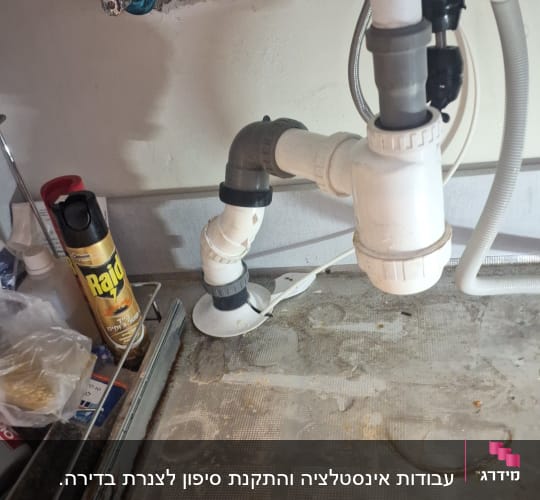 צנרת מתחת לכיור עם חיבורים וכלים
